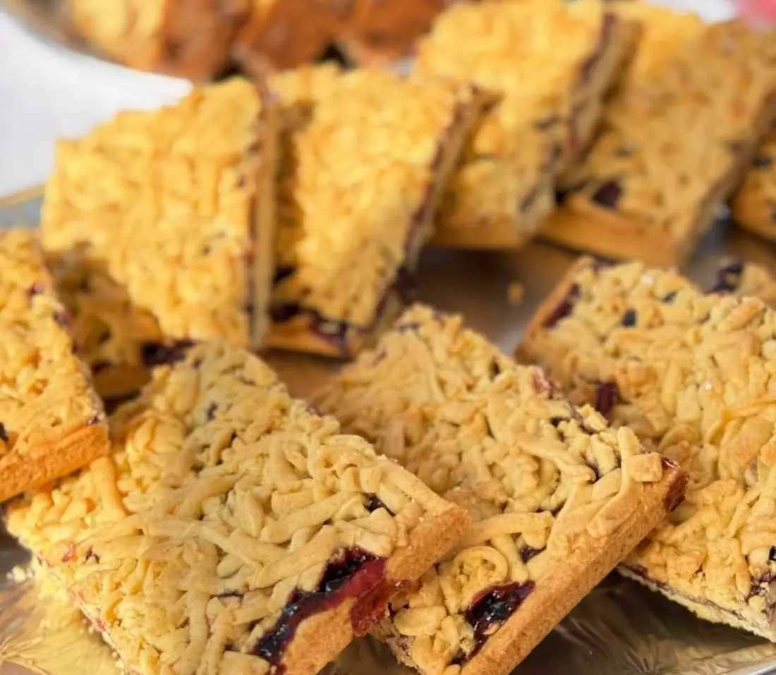 Blackcurrant crumble shortbread bars on a gold platter